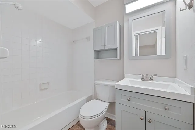 a bathroom with a toilet a sink a mirror and a bathtub