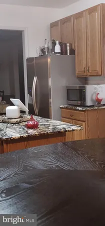 a view of a kitchen with kitchen island and stainless steel appliances