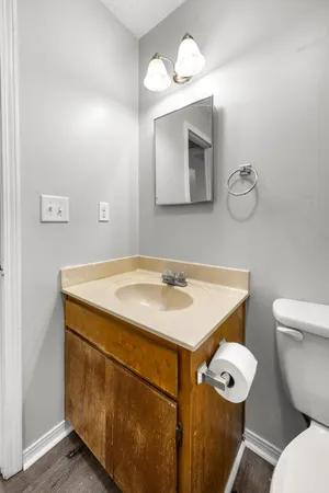 an empty room with wooden floor closet and windows