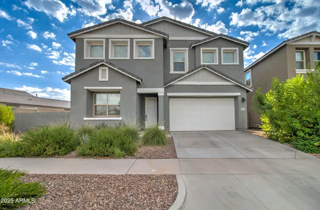 a front view of a house with a yard and trees