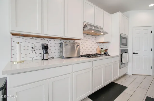 a kitchen with stainless steel appliances a stove microwave and cabinets