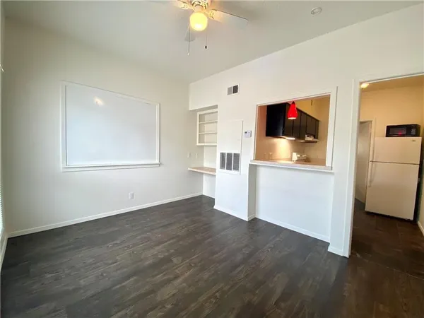 a view of a kitchen with wooden floor and a refrigerator