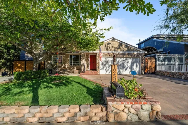 a front view of a house with a yard and a garden