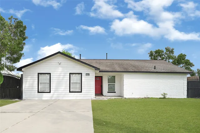a view of a yard in front of a house with a large tree