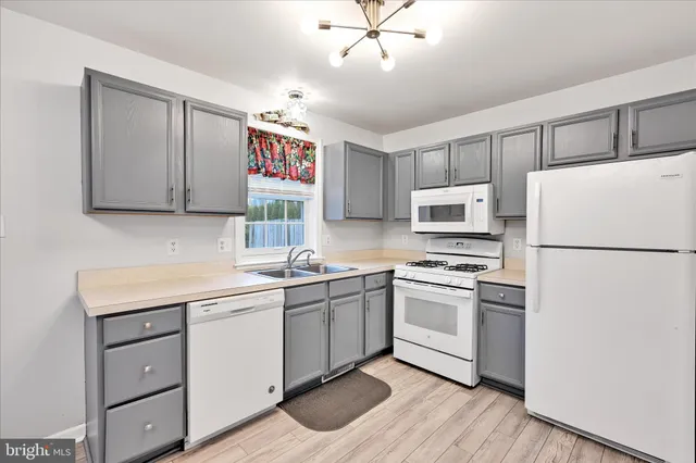 a kitchen with a sink a refrigerator and cabinets
