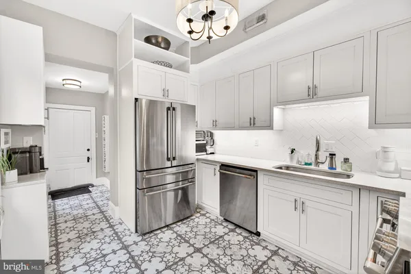a kitchen with granite countertop a sink a counter space appliances and cabinets