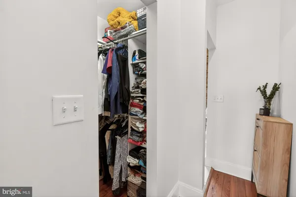 a view of walk in closet with clothes and shoes