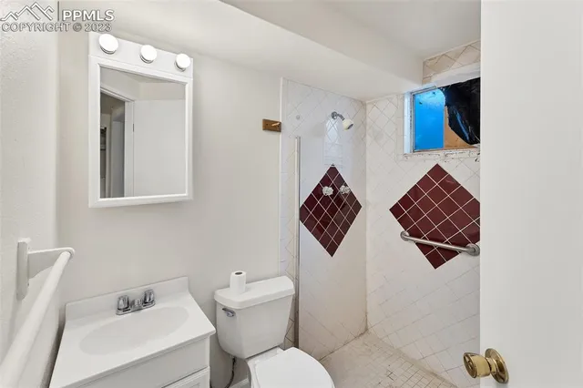 a bathroom with a toilet sink and mirror