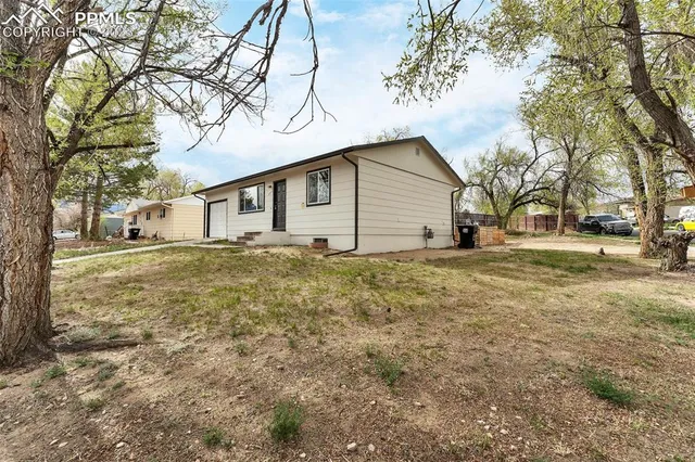 a front view of house with yard and trees around