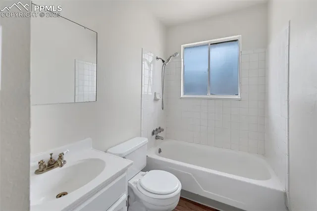 a bath room with a toilet a sink and a bath tub