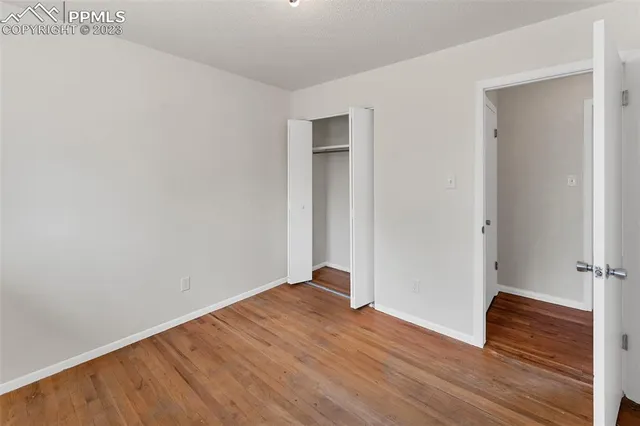 an empty room with wooden floor and closet