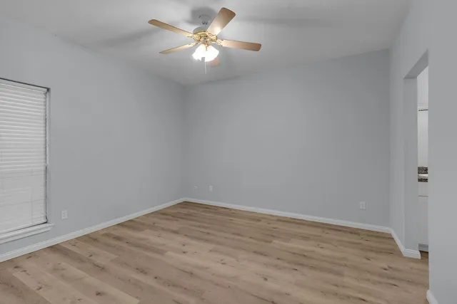 a view of empty room with wooden floor
