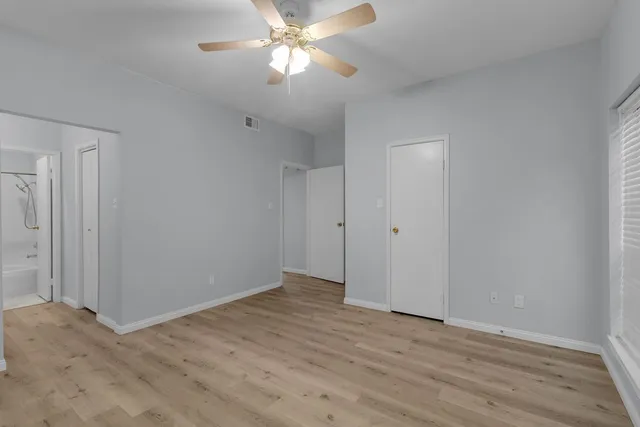 a view of an empty room with wooden floor
