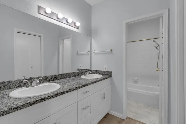 a bathroom with a granite countertop sink and a mirror