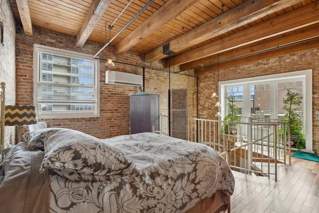 a bedroom with a large bed and a large window with balcony view