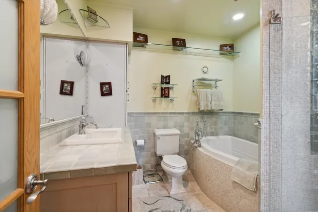 a bathroom with a granite countertop sink a toilet and shower