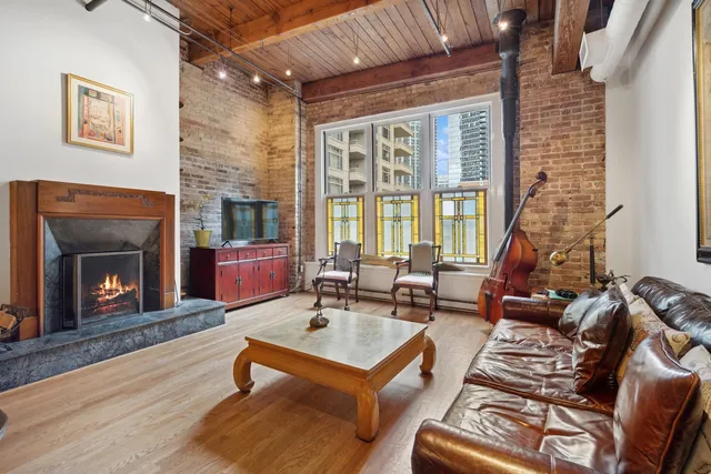 a living room with furniture a fireplace and a floor to ceiling window
