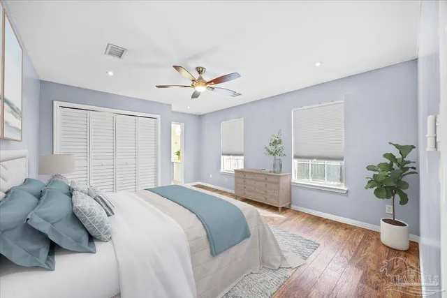 a spacious bedroom with a large bed a potted plant and a window
