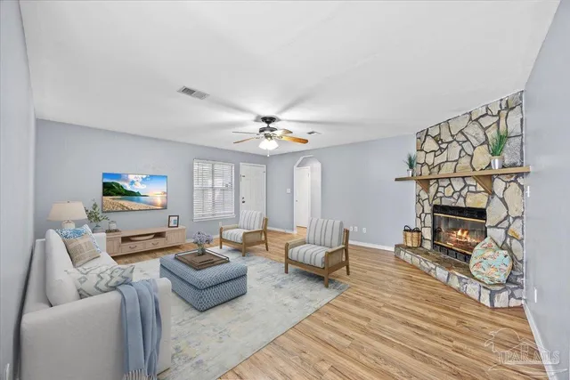 a living room with furniture and a flat screen tv with wooden floor