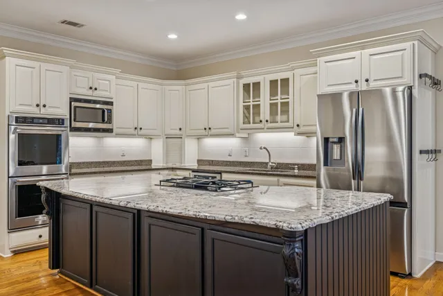 a kitchen with kitchen island granite countertop a sink stove and refrigerator