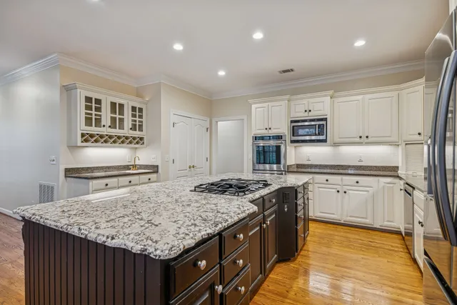 a kitchen with kitchen island granite countertop a stove sink and cabinets