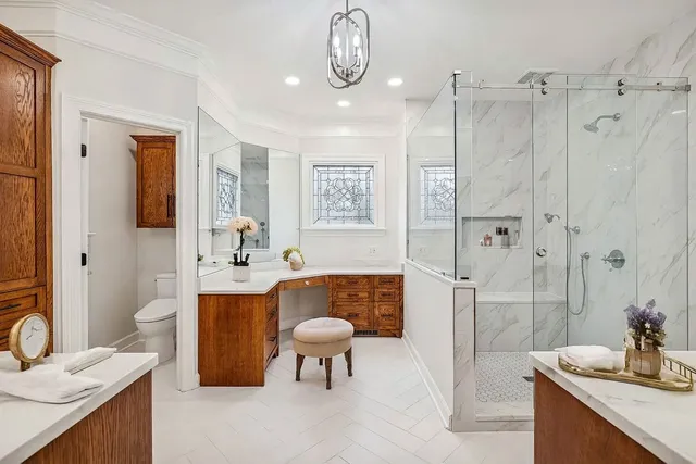 a spacious bathroom with a granite countertop sink a toilet a mirror and shower
