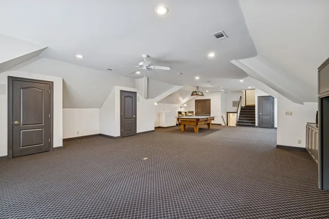 a view of an empty room with a chandelier fan