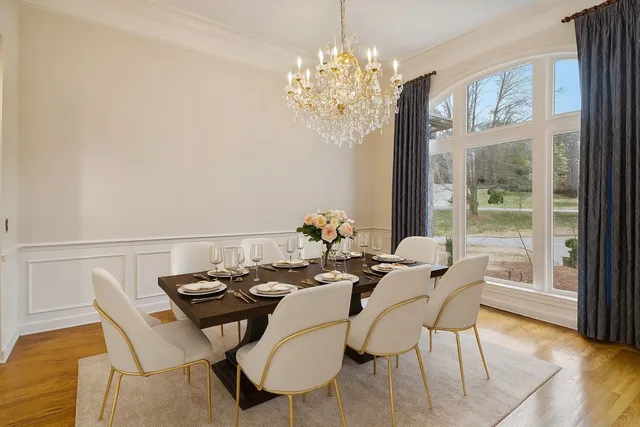a view of a dining room with furniture a chandelier and wooden floor