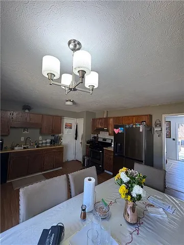 a dining room filled chandelier and kitchen view