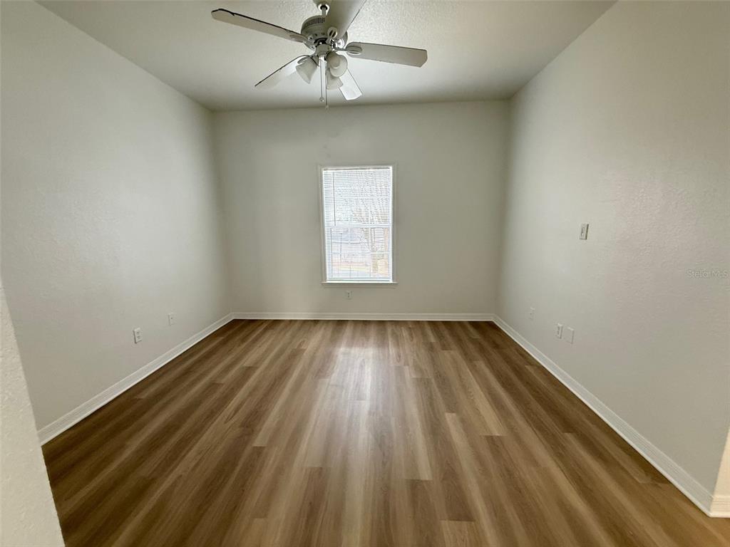 3611 Conroy Road, Unit 825 Orlando, FL 32839 - Photo 10 of 27 an empty room with wooden floor window and ceiling fan
