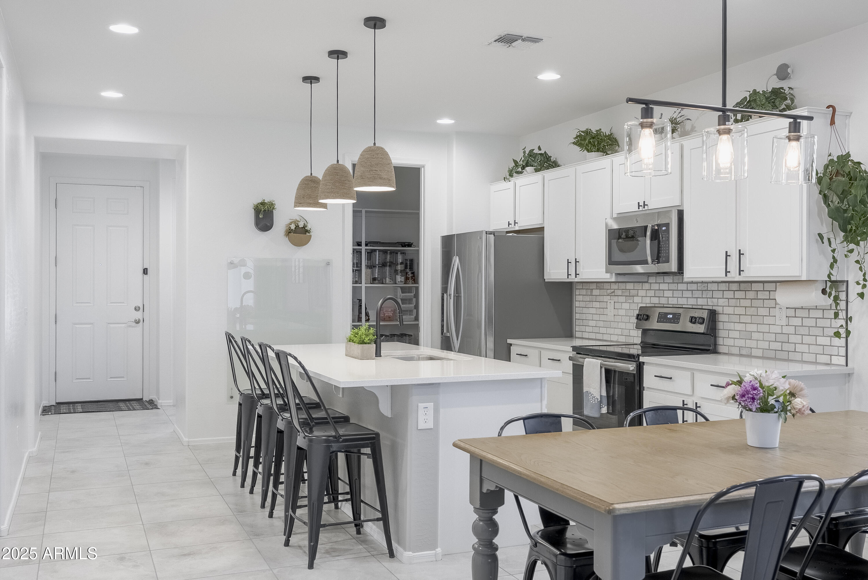 22638 East Quintero Court Queen Creek, AZ 85142 - Photo 13 of 39 a kitchen with stainless steel appliances granite countertop a dining table chairs stove refrigerator and microwave