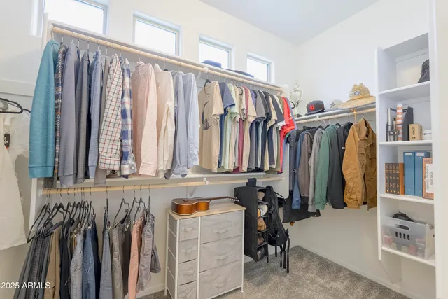 a view of walk in closet with clothes