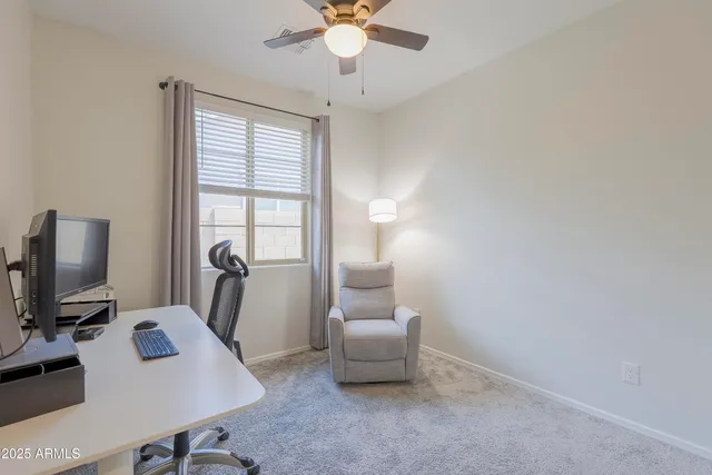a view of a workspace with furniture and a window