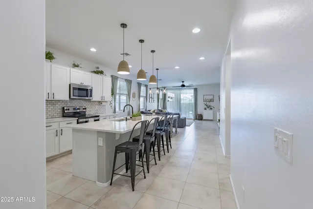 a kitchen with cabinets and chairs