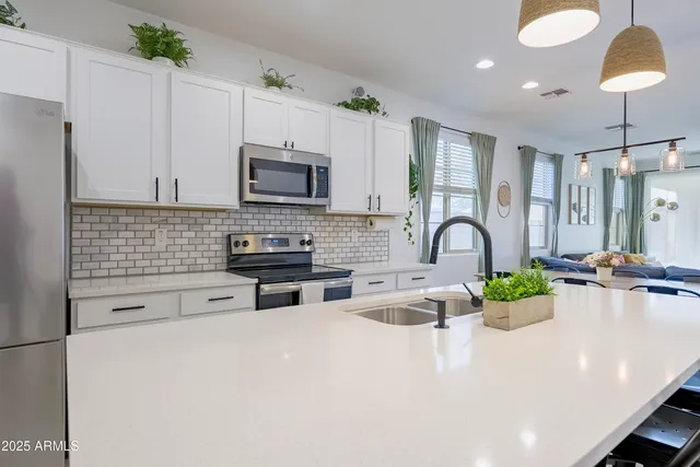 a kitchen with kitchen island a white cabinets and appliances