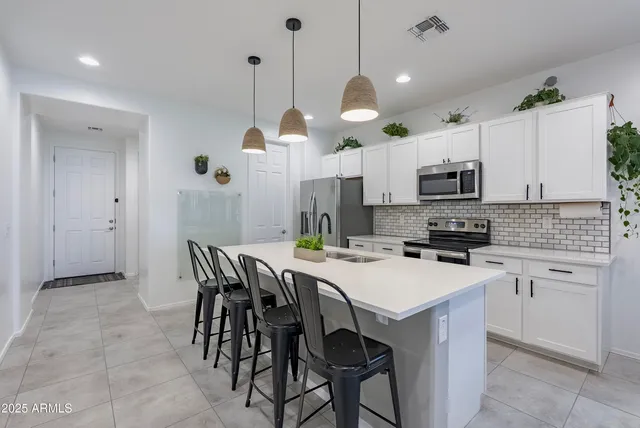 a kitchen with kitchen island a dining table chairs and a sink