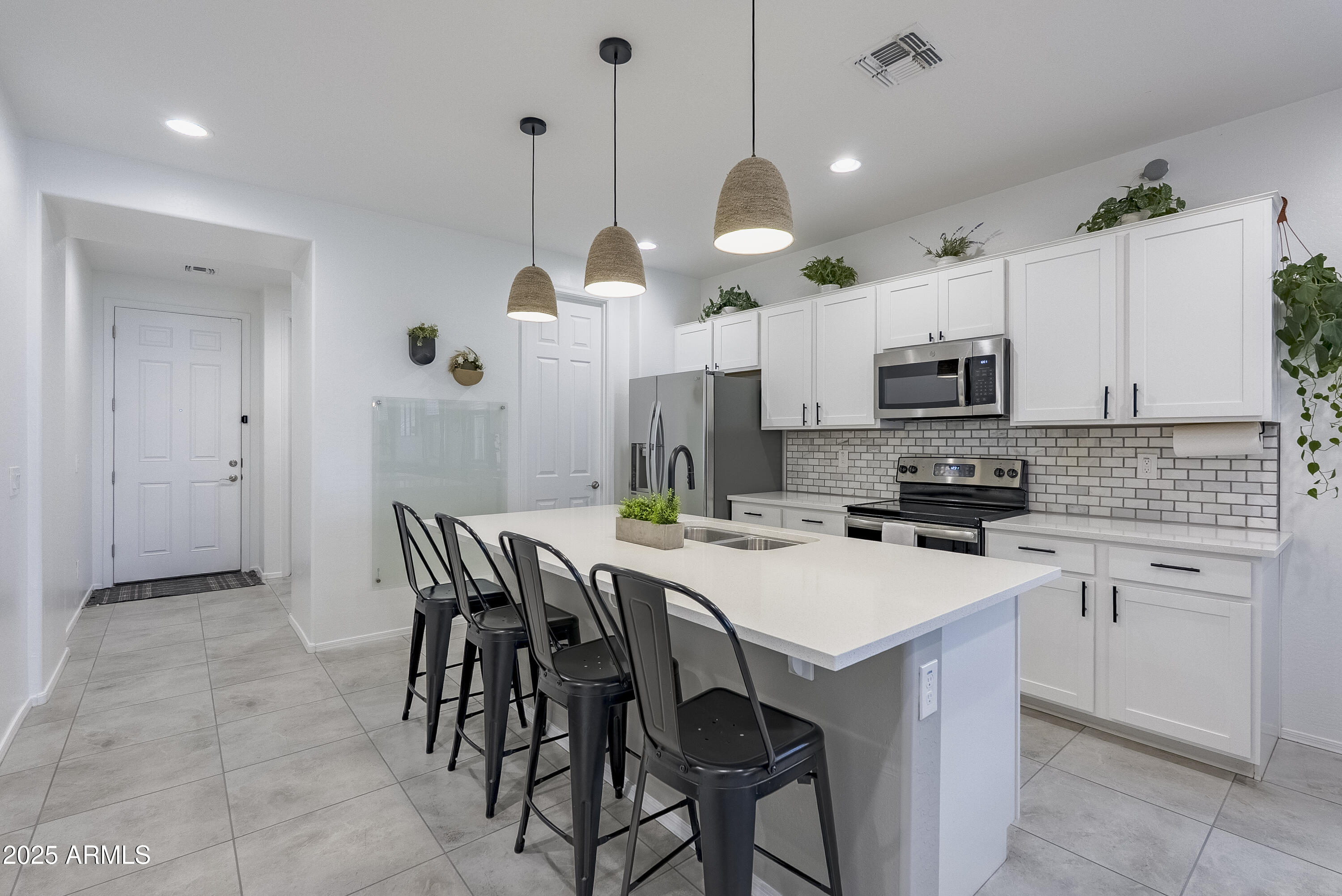 22638 East Quintero Court Queen Creek, AZ 85142 - Photo 9 of 39 a kitchen with kitchen island a dining table chairs and a sink