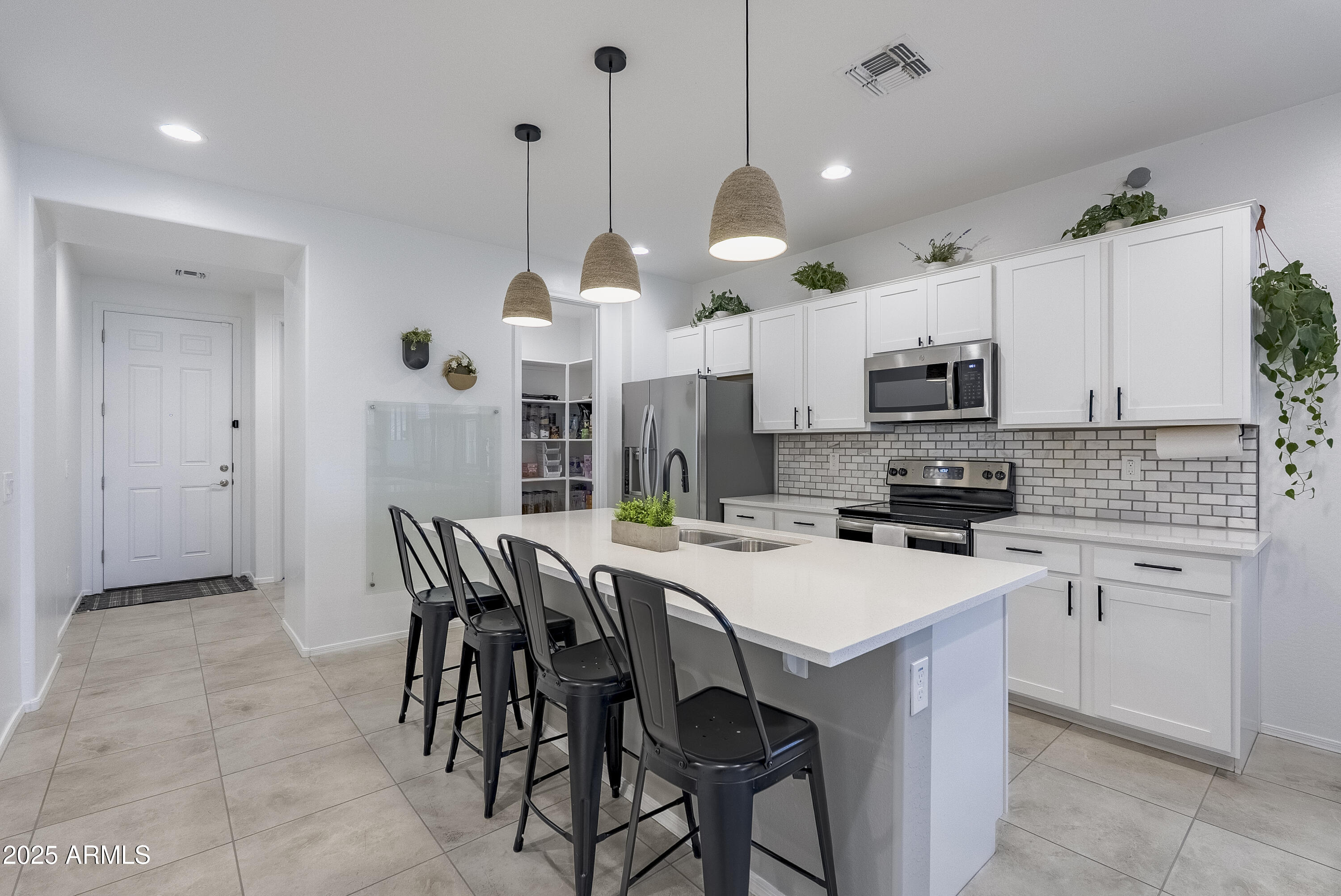 22638 East Quintero Court Queen Creek, AZ 85142 - Photo 10 of 39 a kitchen with stainless steel appliances a white table chairs and a refrigerator