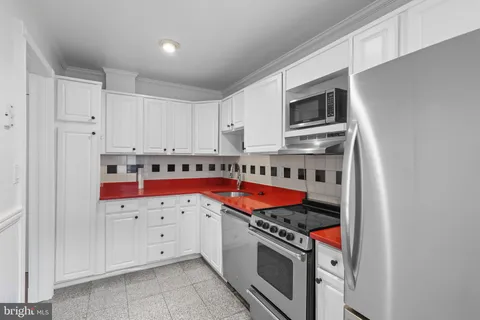 a kitchen with stainless steel appliances granite countertop a stove and a microwave