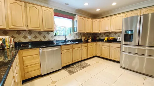 a kitchen with stainless steel appliances granite countertop a refrigerator sink and cabinets