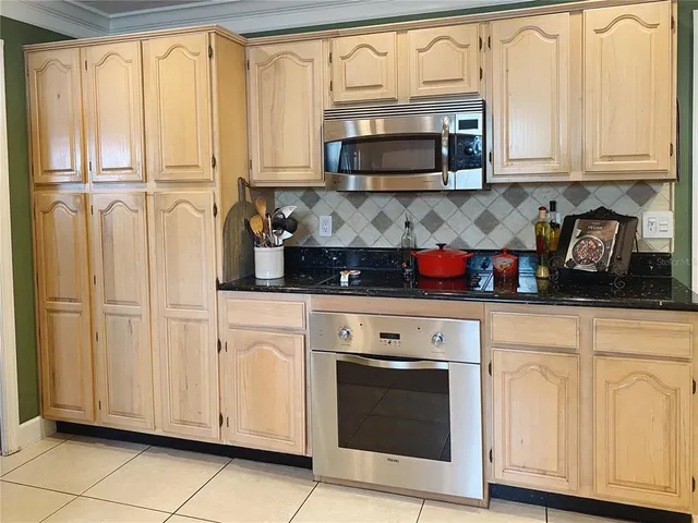 a kitchen with stainless steel appliances granite countertop white cabinets granite counter tops and a wooden floors