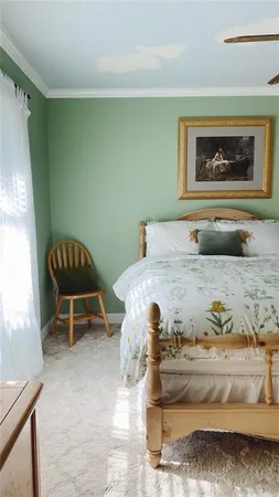 a bedroom with a bed and a painting on the wall