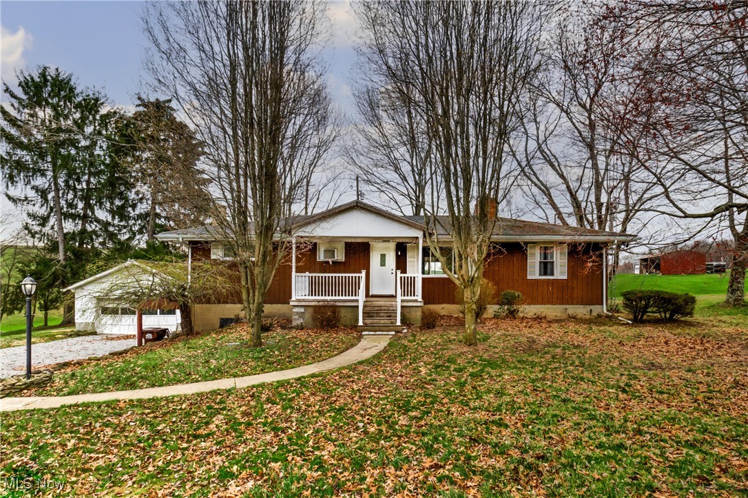 Single story home with a front yard, a porch, a garage, and a chimney