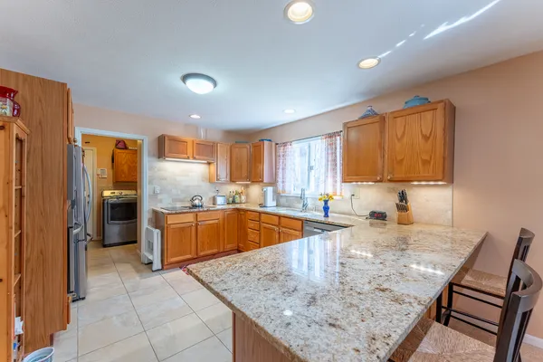 a kitchen with stainless steel appliances granite countertop a sink counter space cabinets and a large window