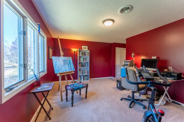a view of a workspace with furniture and a window