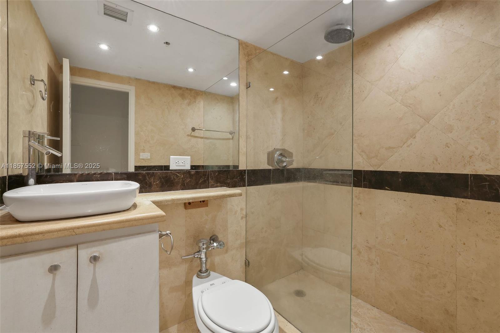 1500 Bay Road, Unit S0442 Miami Beach, FL 33139 - Photo 14 of 75 a bathroom with a granite countertop sink mirror vanity and toilet