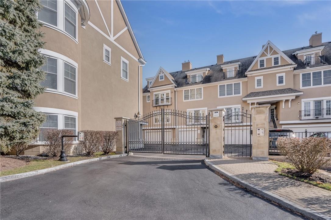 a view of a white house with iron fence