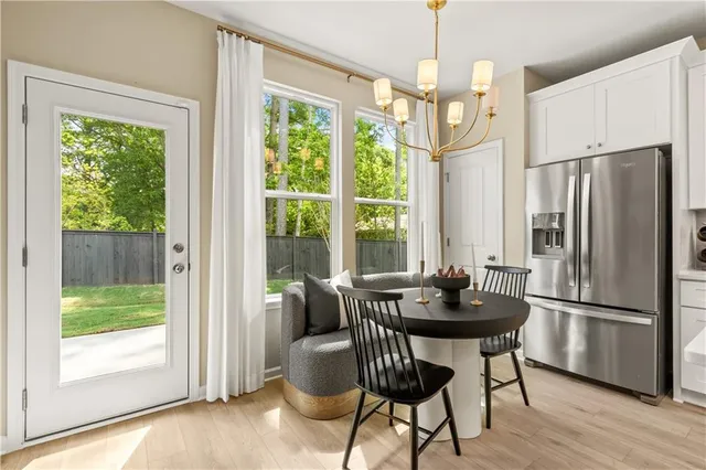 a dining room with furniture a chandelier and wooden floor