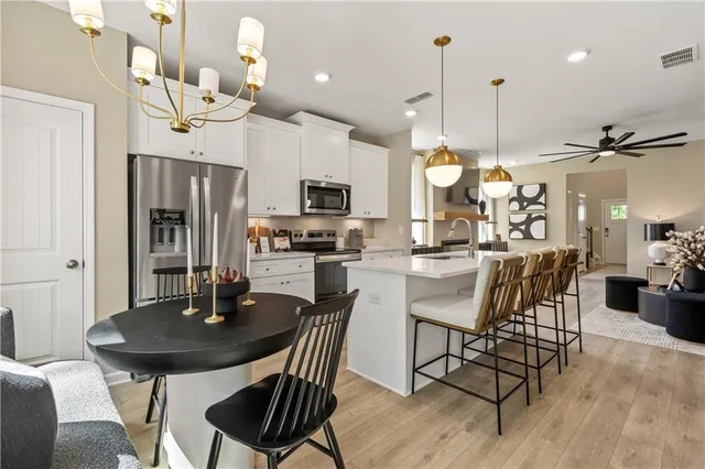 a dining room filled chandelier and wooden floor