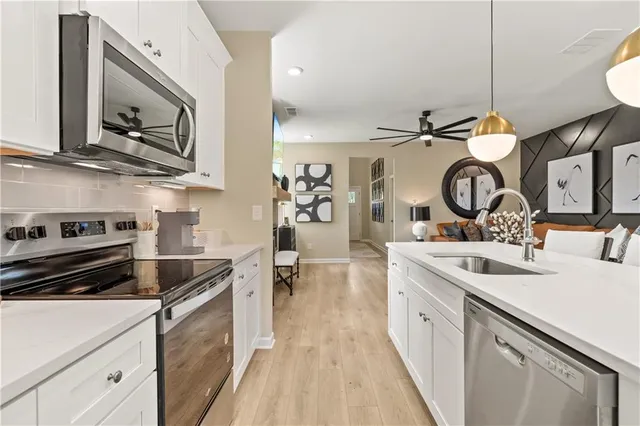 a kitchen with a sink and a stove with wooden floor